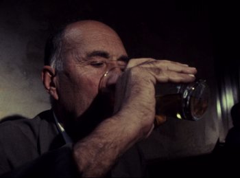 Movie still from “Baal” (1970), directed by Volker Schlöndorff – An older man drinking a beer from a glass; Close Up shot, Low angle