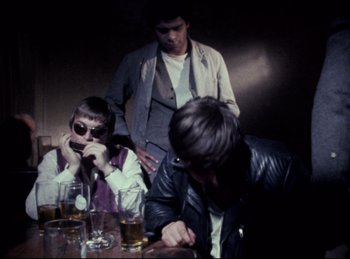 Movie still from “Baal” (1970), directed by Volker Schlöndorff – A group of people sitting at a table with drinks; Medium shot, High angle