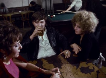 Movie still from “Baal” (1970), directed by Volker Schlöndorff – A group of people sitting around a pool table; Medium shot, High angle