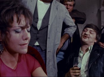 Movie still from “Baal” (1970), directed by Volker Schlöndorff – A group of people sitting in a room together; Close Up shot, High angle