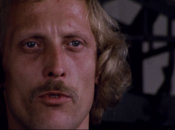 Movie still from “Baal” (1970), directed by Volker Schlöndorff – A person with long blonde hair; Close Up shot, Low angle