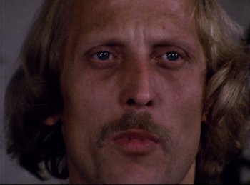 Movie still from “Baal” (1970), directed by Volker Schlöndorff – A person with long hair and a mustache; Close Up shot, Low angle