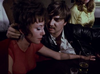 Movie still from “Baal” (1970), directed by Volker Schlöndorff – A man and a woman sitting next to each other at a table; Close Up shot, High angle