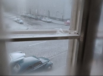 Movie still from “Baal” (1970), directed by Volker Schlöndorff – Cars parked in a parking lot on a rainy day; Wide shot, High angle