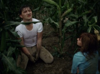 Movie still from “Baal” (1970), directed by Volker Schlöndorff – A man and a little girl in a corn field; Medium shot, High angle
