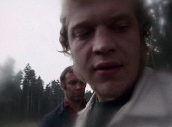 Movie still from “Baal” (1970), directed by Volker Schlöndorff – Two men standing next to each other on a field; Close Up shot, Low angle