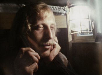 Movie still from “Baal” (1970), directed by Volker Schlöndorff – A man holding his mouth open while wearing a sweater; Close Up shot, Low angle