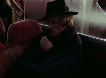 Movie still from “Baal” (1970), directed by Volker Schlöndorff – A man sitting on a bus wearing a hat; Close Up shot, High angle