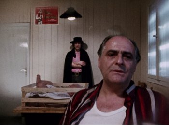 Movie still from “Baal” (1970), directed by Volker Schlöndorff – A man and a woman standing in front of a table; Medium shot, Low angle