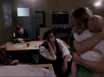 Movie still from “Baal” (1970), directed by Volker Schlöndorff – A group of people sitting around a table; Medium shot, Over the shoulder angle