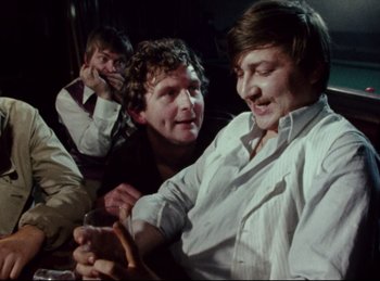 Movie still from “Baal” (1970), directed by Volker Schlöndorff – A group of men sitting next to each other on the ground; Close Up shot, Over the shoulder angle
