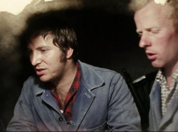 Movie still from “Baal” (1970), directed by Volker Schlöndorff – A man in a blue jacket and a man in a red plaid shirt; Close Up shot, Over the shoulder angle