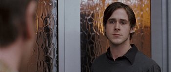 Movie still from “Stay” (2005), directed by Marc Forster – A man standing in front of a chain - link fence; Close Up shot, Over the shoulder angle