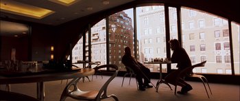 Movie still from “Stay” (2005), directed by Marc Forster – A man sitting in a chair in front of large windows; Wide shot, High angle