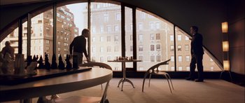 Movie still from “Stay” (2005), directed by Marc Forster – A person standing in a room with a table and chairs; Wide shot, Over the shoulder angle
