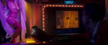 Movie still from “Stay” (2005), directed by Marc Forster – A person sitting on a stage in front of a television; Wide shot, Over the shoulder angle