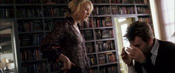 Movie still from “Stay” (2005), directed by Marc Forster – A woman standing in front of bookshelves in a room; Medium shot, Over the shoulder angle