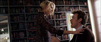 Movie still from “Stay” (2005), directed by Marc Forster – A woman in a black and white dress is holding a book; Medium shot, Over the shoulder angle