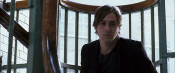 Movie still from “Stay” (2005), directed by Marc Forster – A man sitting on top of a wooden railing; Close Up shot, Over the shoulder angle