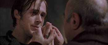 Movie still from “Stay” (2005), directed by Marc Forster – A person putting something in his ear; Close Up shot, Over the shoulder angle