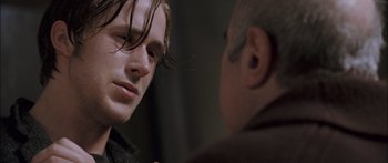 Movie still from “Stay” (2005), directed by Marc Forster – A man looking at another man in a dark room; Close Up shot, Over the shoulder angle