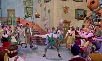 Movie still from “Babes in Toyland” (1961), directed by Jack Donohue – A group of people standing in a room; Wide shot, Low angle