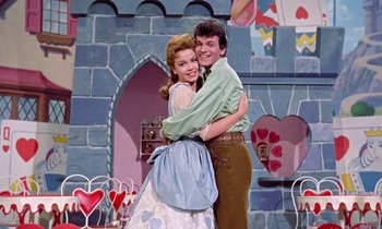 Movie still from “Babes in Toyland” (1961), directed by Jack Donohue – A man and a woman hugging in front of a castle; Medium shot, Low angle