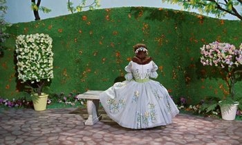 Movie still from “Babes in Toyland” (1961), directed by Jack Donohue – A painting of a woman sitting on a park bench; Wide shot, High angle
