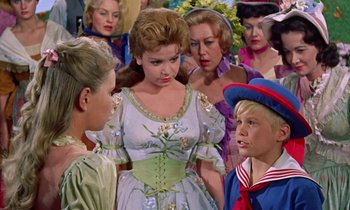 Movie still from “Babes in Toyland” (1961), directed by Jack Donohue – A group of young people standing around each other; Medium shot, Over the shoulder angle