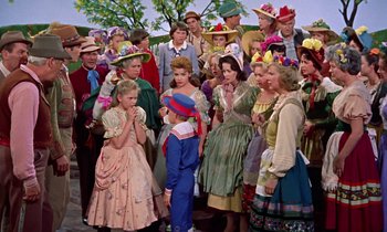Movie still from “Babes in Toyland” (1961), directed by Jack Donohue – A group of people standing next to each other in costumes; Medium shot, High angle