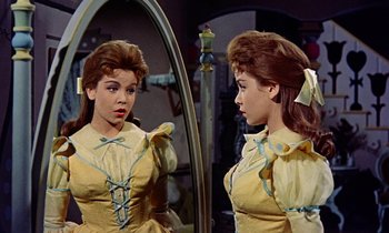 Movie still from “Babes in Toyland” (1961), directed by Jack Donohue – A woman in a yellow dress looking in a mirror; Close Up shot, Over the shoulder angle