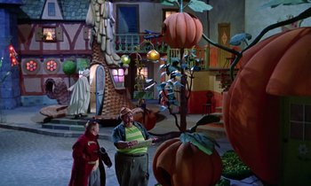 Movie still from “Babes in Toyland” (1961), directed by Jack Donohue – A couple of people standing next to a tree; Wide shot, High angle