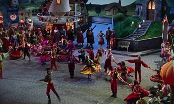 Movie still from “Babes in Toyland” (1961), directed by Jack Donohue – A group of people dressed in colorful costumes dancing; Wide shot, High angle