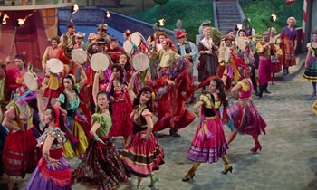 Movie still from “Babes in Toyland” (1961), directed by Jack Donohue – A group of people dressed in colorful costumes; Wide shot, High angle