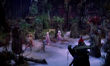 Movie still from “Babes in Toyland” (1961), directed by Jack Donohue – A group of people standing in the middle of a forest; Extreme Wide shot, High angle