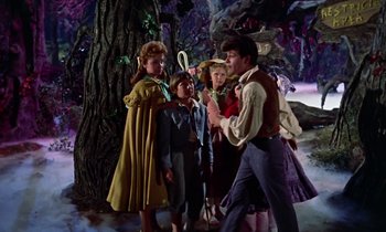 Movie still from “Babes in Toyland” (1961), directed by Jack Donohue – A group of people standing next to each other near a tree; Medium shot, Low angle