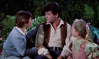 Movie still from “Babes in Toyland” (1961), directed by Jack Donohue – A man in a pirate costume sitting next to two other people; Medium shot, Over the shoulder angle