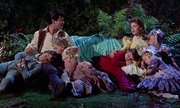 Movie still from “Babes in Toyland” (1961), directed by Jack Donohue – A group of people sitting on the grass; Wide shot, High angle
