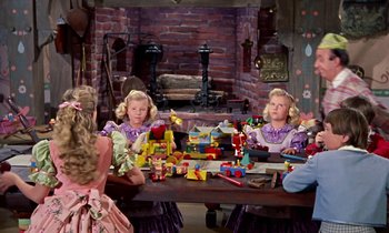 Movie still from “Babes in Toyland” (1961), directed by Jack Donohue – A group of children sitting at a table with toys; Medium shot, High angle