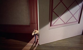 Movie still from “Babes in Toyland” (1961), directed by Jack Donohue – A toy man standing in front of a wall; Extreme Wide shot, High angle