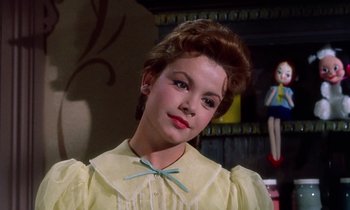 Movie still from “Babes in Toyland” (1961), directed by Jack Donohue – A young woman in a yellow dress with a blue bow in her hair; Close Up shot, Low angle