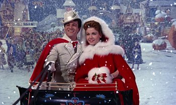 Movie still from “Babes in Toyland” (1961), directed by Jack Donohue – A man and a woman dressed as santa claus in a sleigh; Medium shot, Low angle