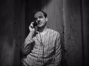 Movie still from “Baby Doll” (1956), directed by Elia Kazan – A black and white photo of a man talking on a phone; Medium shot, High angle