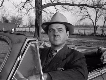 Movie still from “Baby Doll” (1956), directed by Elia Kazan – A man in a suit and a hat sitting in the back seat of a car; Close Up shot, Low angle