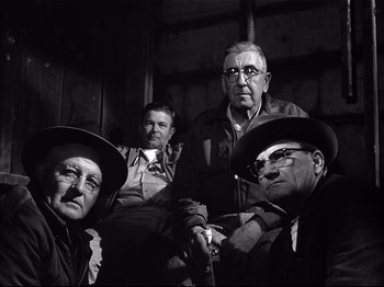 Movie still from “Baby Doll” (1956), directed by Elia Kazan – A black and white photo of a group of men; Medium shot, Low angle
