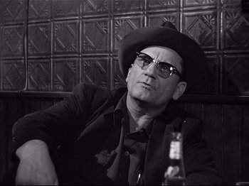 Movie still from “Baby Doll” (1956), directed by Elia Kazan – A black and white photo of a man in a hat and glasses; Close Up shot, Low angle