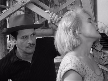 Movie still from “Baby Doll” (1956), directed by Elia Kazan – A man in a hat is holding a woman's head; Close Up shot, Over the shoulder angle