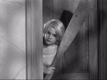 Movie still from “Baby Doll” (1956), directed by Elia Kazan – A young girl hiding behind a wooden door; Medium shot, High angle