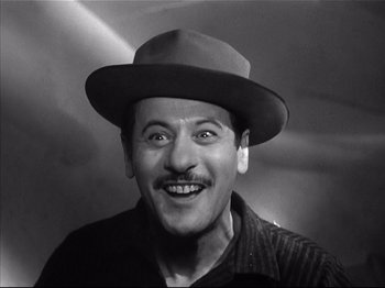 Movie still from “Baby Doll” (1956), directed by Elia Kazan – A man wearing a hat and smiling for the camera; Close Up shot, Low angle