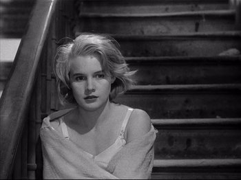 Movie still from “Baby Doll” (1956), directed by Elia Kazan – A woman sitting on top of a set of stairs; Close Up shot, High angle